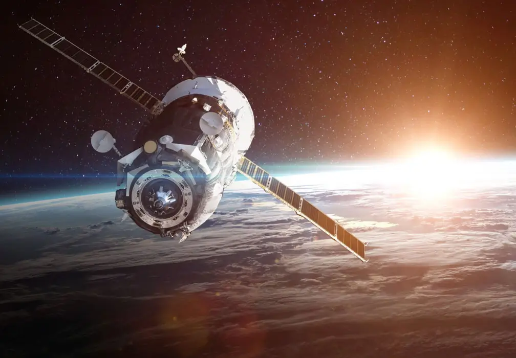 A satellite orbiting Earth with the sun rising in the background, representing space exploration, communication technology, and advanced aerospace engineering.